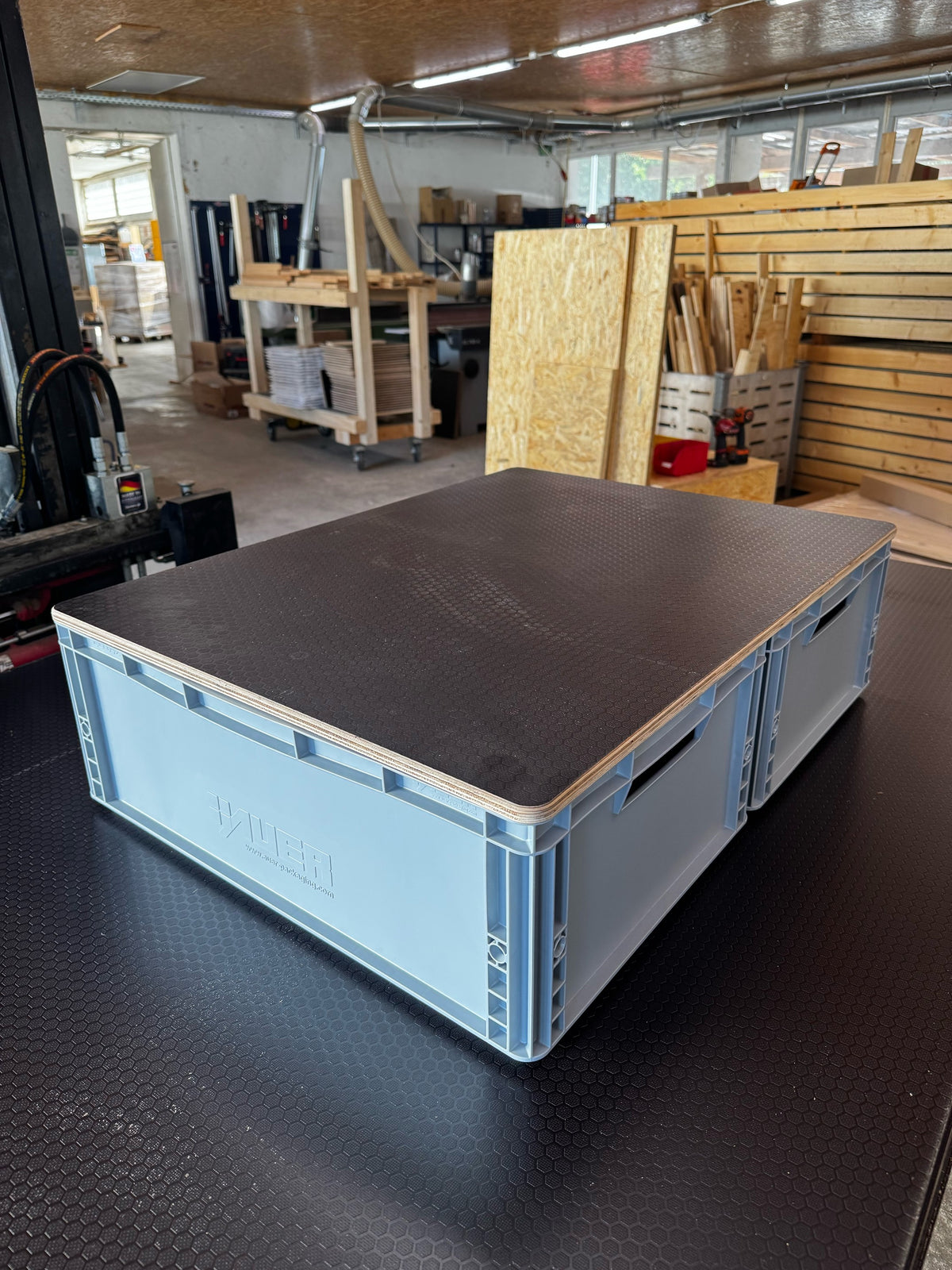 Eurobox-Doppeldeckel mit rutschfester Hexagon-Oberfläche, aufgelegt über zwei nebeneinanderstehende Euroboxen, Schrägansicht in der Werkstatt