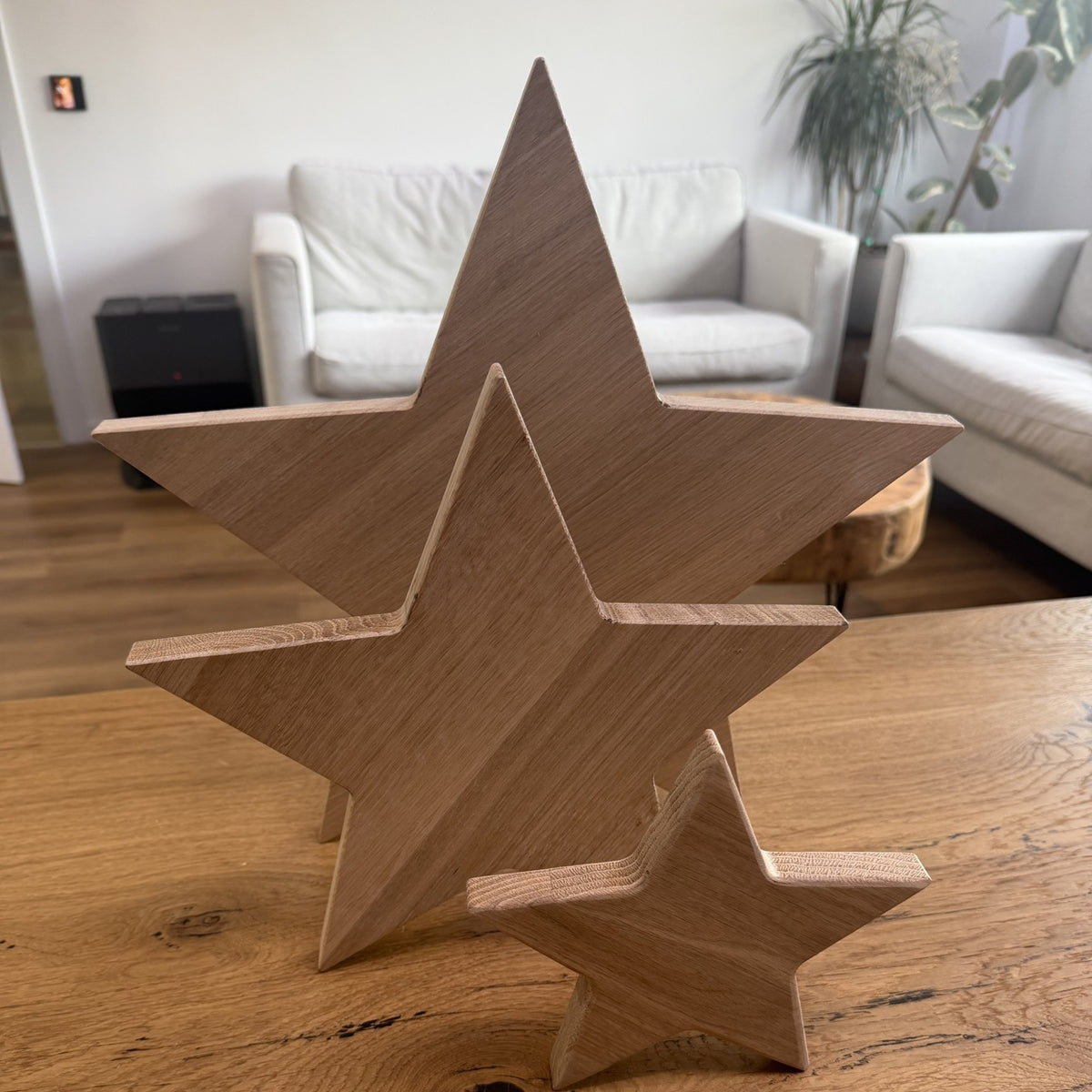 Holzstern-Set aus massiver Eiche, drei Größen frei stehend auf dem Tisch