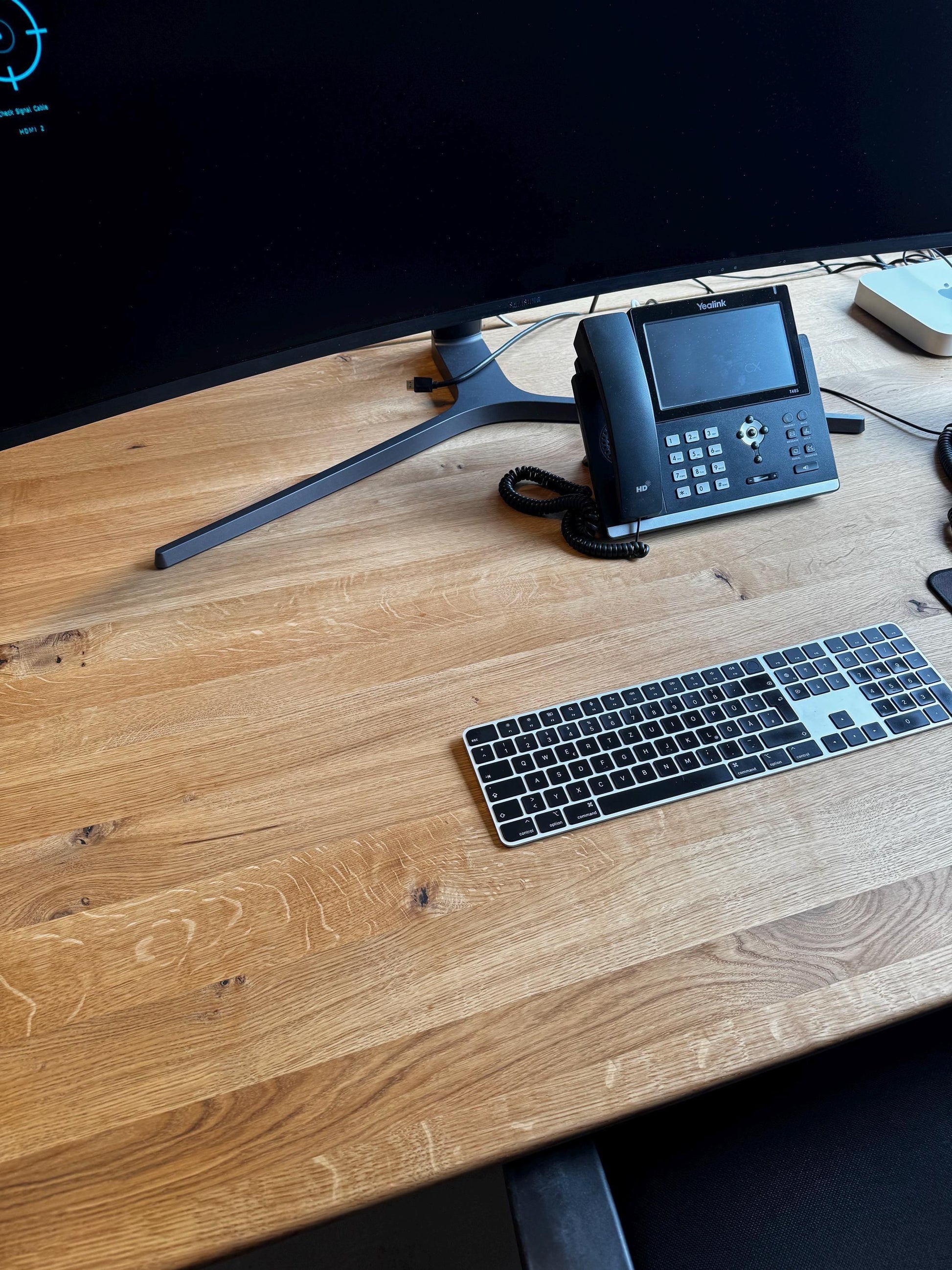 Blick von oben auf die geölte Wildeiche-Platte mit Tastatur und Telefon