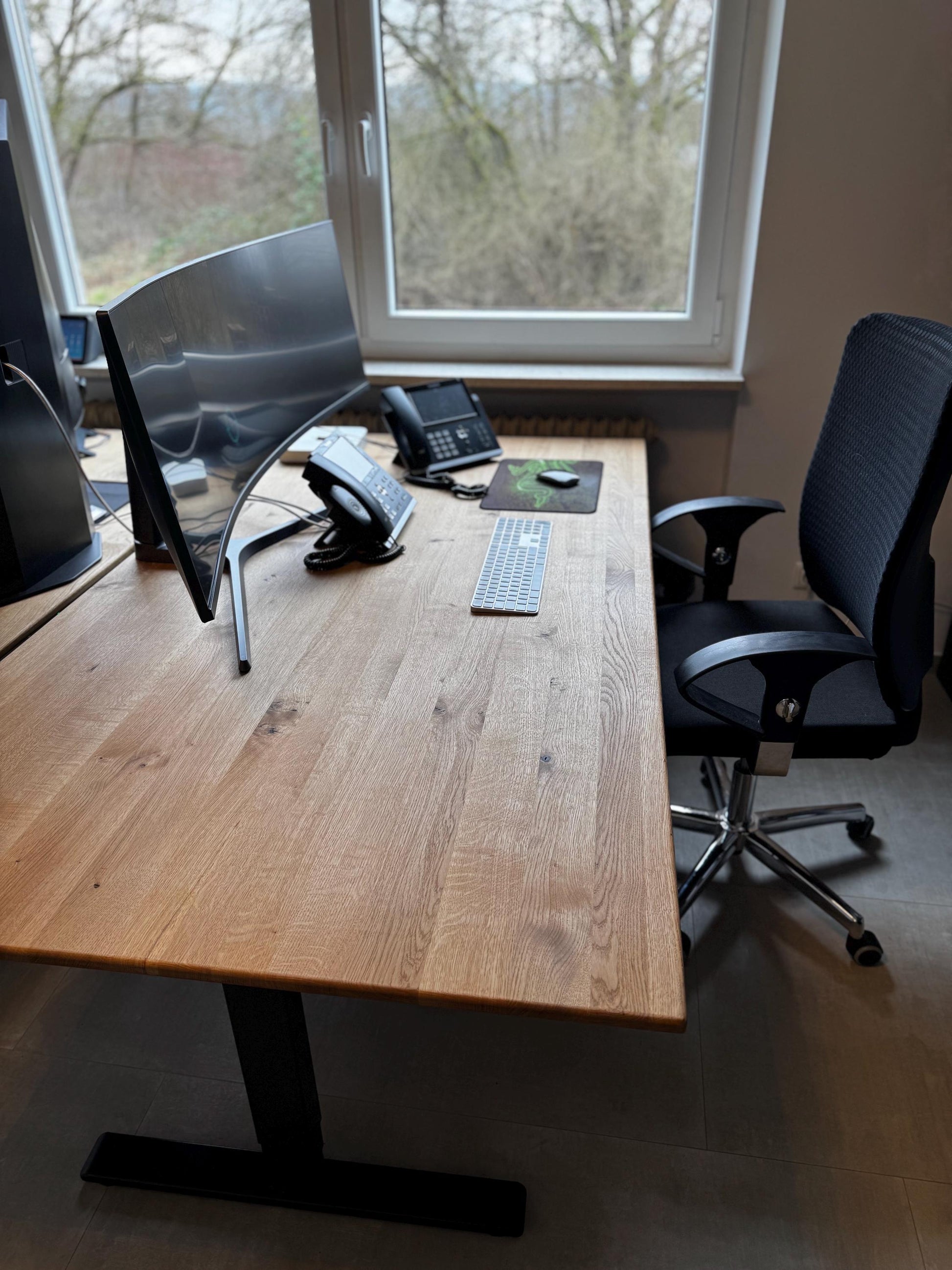 Schreibtischplatte aus Wildeiche auf schwarzem Gestell, eingerichtet als Arbeitsplatz am Fenster