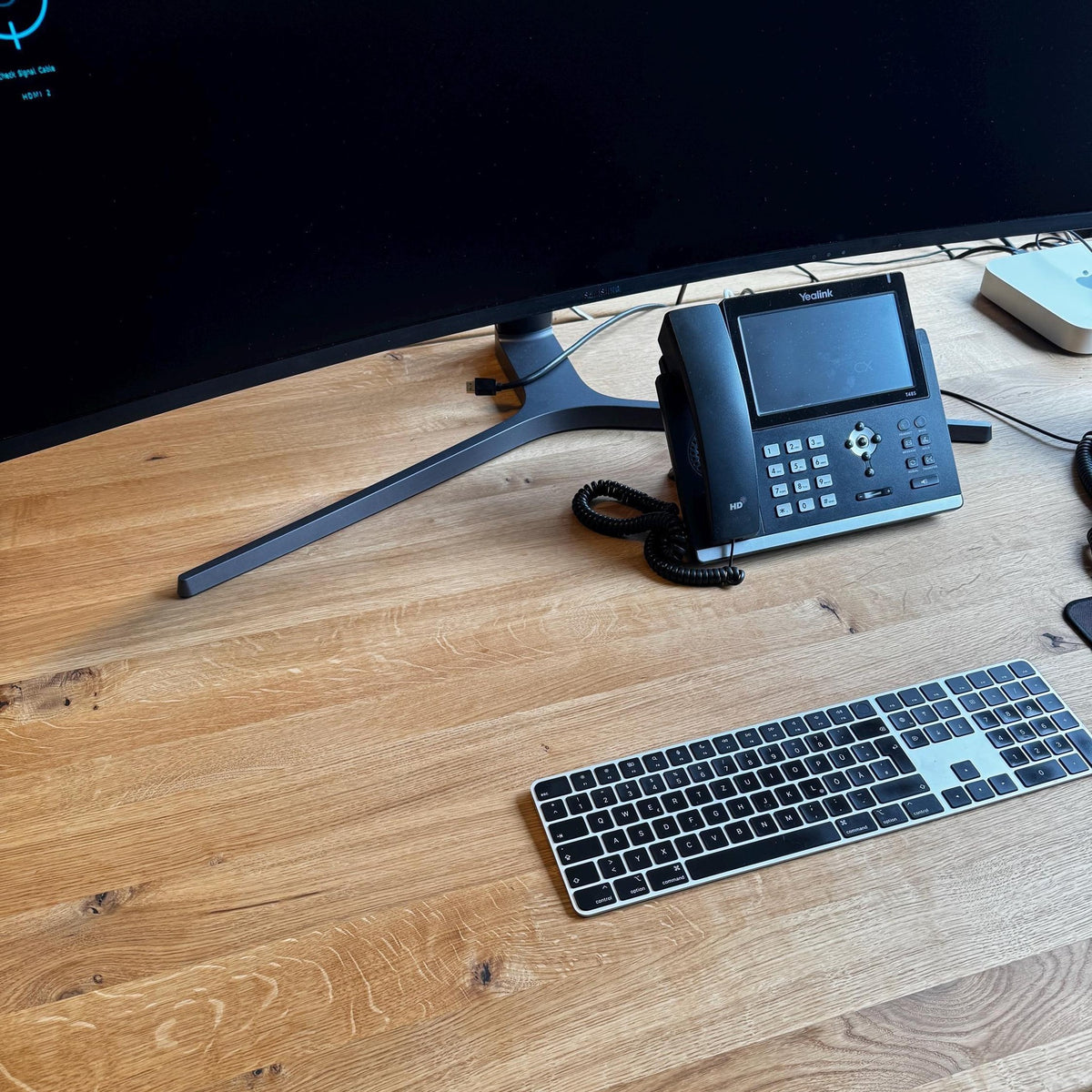 Blick von oben auf die geölte Wildeiche-Platte mit Tastatur und Telefon